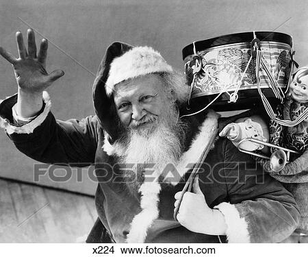 Picture - 1930 1930S Santa Claus Holding Bag Of Gifts Drum Dolls Waving At Camera . Fotosearch