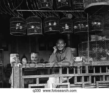1930 1930S Smiling Chinese Man In Shop With Birdcages Bird Vender Seller In Shanghai City China Retro Rrr View Large Photo Image Stock Image - 1930 1930S Smiling Chinese Man In Shop With Birdcages Bird Vender Seller In Shanghai City China Retro Rrr . Fotosearch