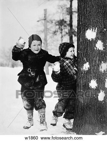 1930 1930S Two Bous Playing In The Snow Hiding Behind Tree With Snowballs In Hands Have A Snowball Fight View Large Photo Image Stock Image - 1930 1930S Two Bous Playing In The Snow Hiding Behind Tree With Snowballs In Hands Have A Snowball Fight . Fotosearch