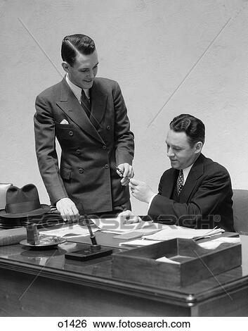 1930 1930S Two Men At Desk In Office Passing Pen View Large Photo Image Stock Photograph - 1930 1930S Two Men At Desk In Office Passing Pen . Fotosearch