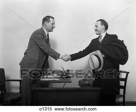 1930 1930S Two Men Shaking Hands At Desk In Office View Large Photo Image Stock Photography - 1930 1930S Two Men Shaking Hands At Desk In Office . Fotosearch