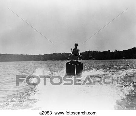 1930 1930S Woman Aquaplaning Water Board Being Towed Behind Boat Skiing Wake Of Tow Sport Sports Nushoka Lake Canada Retro View Large Photo Image Stock Image - 1930 1930S Woman Aquaplaning Water Board Being Towed Behind Boat Skiing Wake Of Tow Sport Sports Nushoka Lake Canada Retro. Fotosearch