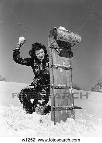 1930 1930S Woman Playing In Snow Hiding Behind Tobaggan Sled Having A Snowball Fight Holdinga Snowball View Large Photo Image Stock Image - 1930 1930S Woman Playing In Snow Hiding Behind Tobaggan Sled Having A Snowball Fight Holdinga Snowball . Fotosearch