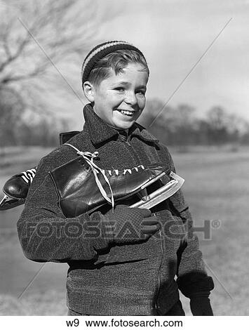 Stock Photo - 1930 1930S Young Boy Holding Ice Skates Outside In Winter . Fotosearch