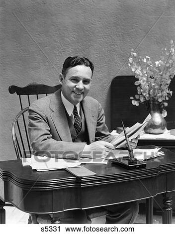 1930S 1940S Business Man At Desk Looking At Camera Holding Papers Smiling Three Piece Suit Tie Pen View Large Photo Image Stock Image - 1930S 1940S Business Man At Desk Looking At Camera Holding Papers Smiling Three Piece Suit Tie Pen . Fotosearch