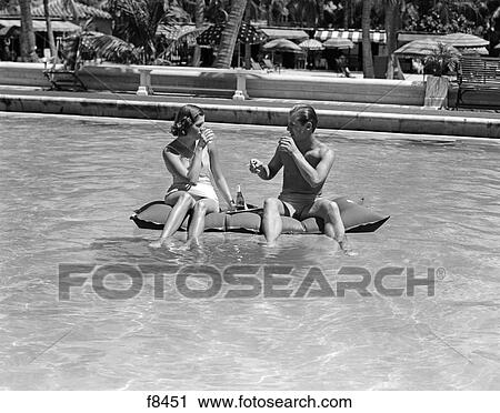 1930S 1940S Couple Drinking While Floating In A Pool On A Rubber Raft At Florida Resort View Large Photo Image Stock Image - 1930S 1940S Couple Drinking While Floating In A Pool On A Rubber Raft At Florida Resort. Fotosearch