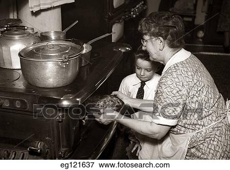 1930S 1940S Grandmother Taking Pie Out Of Over As Boy Watches View Large Photo Image Stock Photo - 1930S 1940S Grandmother Taking Pie Out Of Over As Boy Watches. Fotosearch