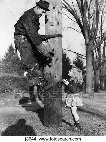 1930S-1940S Linesman Rescuing Kitten For Little Girl View Large Photo Image Picture - 1930S-1940S Linesman Rescuing Kitten For Little Girl . Fotosearch