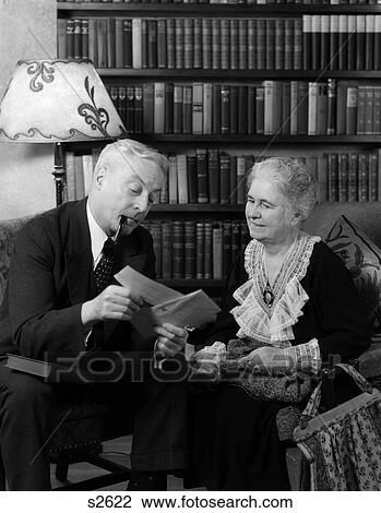 1930S 1940S Retired Man Woman Couple Look At Check In Living Room Retirement Finances Man Smoking Pipe View Large Photo Image Stock Image - 1930S 1940S Retired Man Woman Couple Look At Check In Living Room Retirement Finances Man Smoking Pipe. Fotosearch