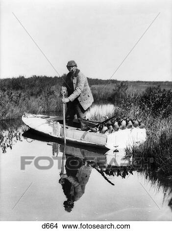 1930S 1940S Senior Man Steering Small Boat Full Of Duck Decoys Shotgun Hunter Hunting View Large Photo Image Picture - 1930S 1940S Senior Man Steering Small Boat Full Of Duck Decoys Shotgun Hunter Hunting . Fotosearch