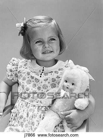 1930S 1940S Smiling Blond Toddler Girl Holding Toy Doll Retro View Large Photo Image Stock Photograph - 1930S 1940S Smiling Blond Toddler Girl Holding Toy Doll Retro . Fotosearch