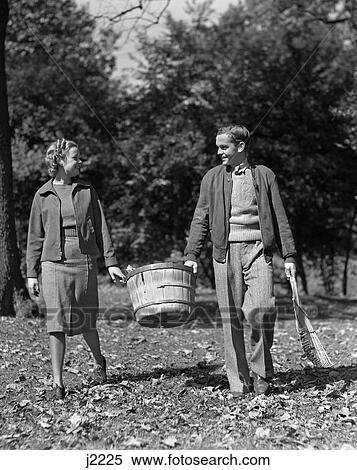 1930S 1940S Teen Couple Carrying Basket Autumn Leaves View Large Photo Image Stock Photography - 1930S 1940S Teen Couple Carrying Basket Autumn Leaves . Fotosearch