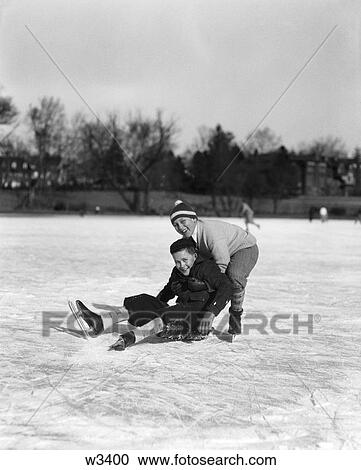 1930S 1940S Two Boys Ice Skating Boy Fallen Other Picking Him Up View Large Photo Image Stock Image - 1930S 1940S Two Boys Ice Skating Boy Fallen Other Picking Him Up . Fotosearch