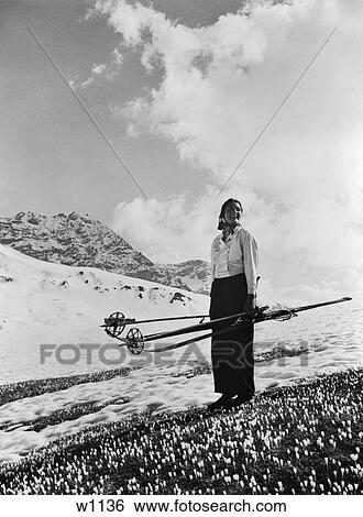 1930S 1940S Woman Holding Skis Poles Standing On Crocuses In Snowy Alps Near Davos Switzerland Spring Change Of Seasons View Large Photo Image Stock Photograph - 1930S 1940S Woman Holding Skis Poles Standing On Crocuses In Snowy Alps Near Davos Switzerland Spring Change Of Seasons. Fotosearch