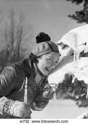 1930S 1940S Woman Licking Snow Off Of Pine Tree Branch Wearing Hat Tam With Pom Pom Tassel Holding Icicle In Hand Smiling Silly View Large Photo Image Stock Image - 1930S 1940S Woman Licking Snow Off Of Pine Tree Branch Wearing Hat Tam With Pom Pom Tassel Holding Icicle In Hand Smiling Silly. Fotosearch