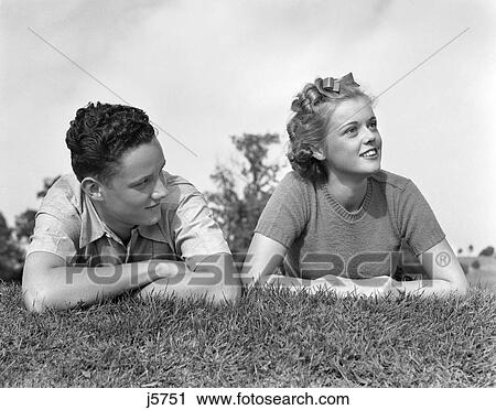 1930S 1940S Young Teen Couple Lying In Grass Head Shoulders Portrait View Large Photo Image Stock Image - 1930S 1940S Young Teen Couple Lying In Grass Head Shoulders Portrait . Fotosearch