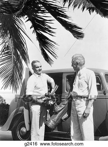 1930S 2 Elderly Men Standing By Car Carrying Golf Bag & Clubs Irons Palm Tree Frond In Corner Tropical Florida View Large Photo Image Stock Photograph - 1930S 2 Elderly Men Standing By Car Carrying Golf Bag & Clubs Irons Palm Tree Frond In Corner Tropical Florida . Fotosearch