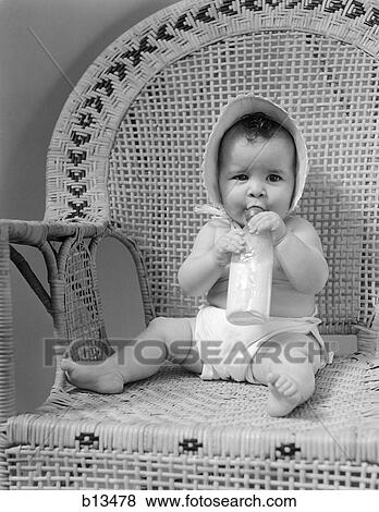 1930S Baby Sitting In Wicker Chair Sucking Milk Bottle View Large Photo Image Stock Photo - 1930S Baby Sitting In Wicker Chair Sucking Milk Bottle . Fotosearch