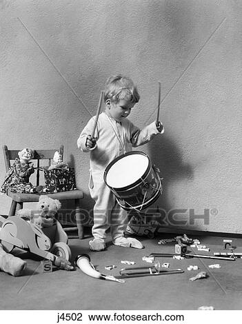 1930S Boy In Pajamas Surrounded By Toys Beating On Toy Drum  View Large Photo Image Stock Image - 1930S Boy In Pajamas Surrounded By Toys Beating On Toy Drum . Fotosearch