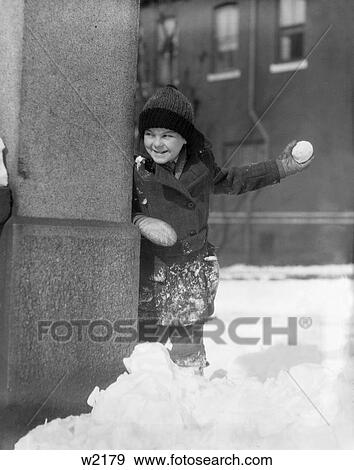 1930S Boy Peeking Around Side Building Throwing A Snowball Winter Fun City View Large Photo Image Stock Photo - 1930S Boy Peeking Around Side Building Throwing A Snowball Winter Fun City . Fotosearch