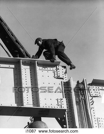 1930S Construction Worker Man On Steel Girder Climbing Wearing Cap View Large Photo Image Stock Photo - 1930S Construction Worker Man On Steel Girder Climbing Wearing Cap . Fotosearch