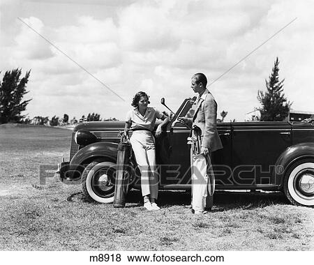 Stock Photo - 1930S Couple Leaning On Convertible Desoto With Golf Bags Talking . Fotosearch