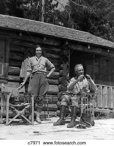 1930S Couple Man Woman Porch Log Cabin Woman Stands By Chair Elderly Man Sits Hold Binoculars Vacation View Large Photo Image Stock Image - 1930S Couple Man Woman Porch Log Cabin Woman Stands By Chair Elderly Man Sits Hold Binoculars Vacation . Fotosearch