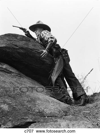 1930S Cowboy On Rocks Aiming Gun View Large Photo Image Stock Photo - 1930S Cowboy On Rocks Aiming Gun . Fotosearch