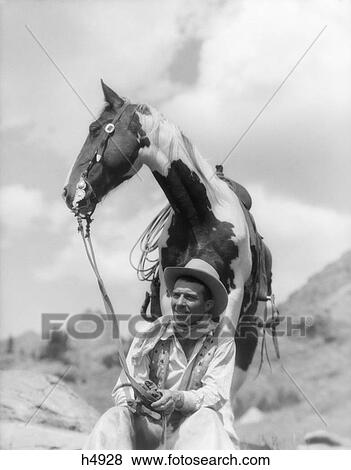1930S Cowboy Sitting In Front Of Horse Holding Reins In Hands Fashion Glacier Park Fifty Mt. Camp Spotted Paint Pinto View Large Photo Image Stock Photo - 1930S Cowboy Sitting In Front Of Horse Holding Reins In Hands Fashion Glacier Park Fifty Mt. Camp Spotted Paint Pinto . Fotosearch
