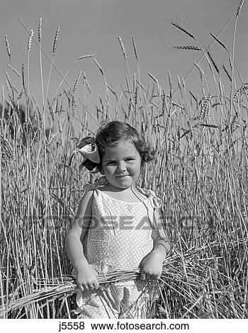 Stock Photo - 1930S Cute Little Girl Standing Wheat Field . Fotosearch