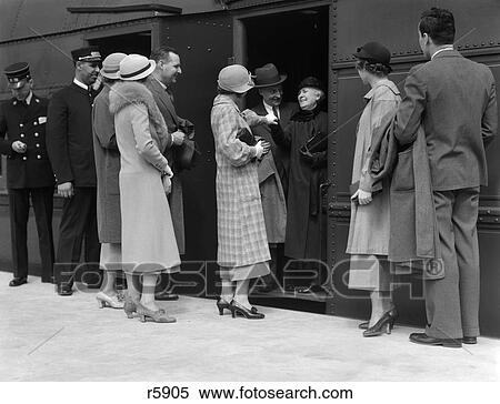Stock Photography - 1930S Family Group Saying Goodbye To Grandmother In Train Going On Trip Travel Conductor. Fotosearch