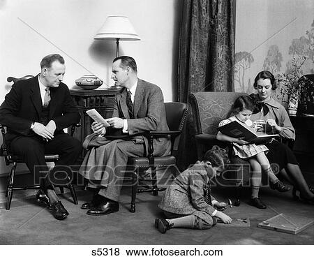 Stock Photo - 1930S Family In Living Room Father Talks To Salesman Insurance Mother Knits In Chair With Daughter . Fotosearch
