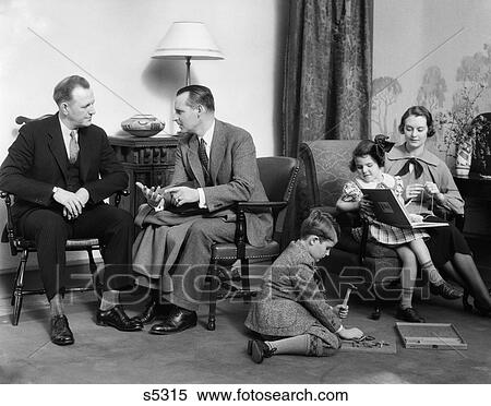 1930S Family In Living Room Mother Knits Daughter On Her Lap With Book Son On Floor With Hammer View Large Photo Image Stock Photography - 1930S Family In Living Room Mother Knits Daughter On Her Lap With Book Son On Floor With Hammer . Fotosearch