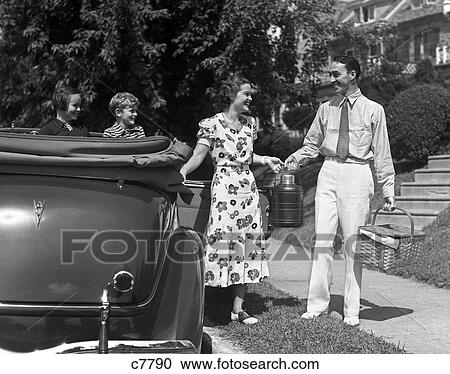Stock Image - 1930S Family Of Four Getting Into Convertible With Picnic Basket & Thermos Jug . Fotosearch