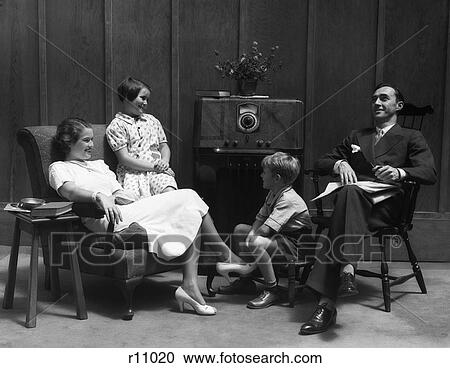 1930S Family Of Four In Living Room Gathered Around Listening To Radio View Large Photo Image Stock Image - 1930S Family Of Four In Living Room Gathered Around Listening To Radio . Fotosearch