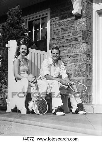 1930S Man And Woman Sitting On Porch Holding Tennis Rackets Smiling Summer Outdoor View Large Photo Image Stock Image - 1930S Man And Woman Sitting On Porch Holding Tennis Rackets Smiling Summer Outdoor . Fotosearch