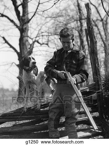1930S Man Holding Double Barrel Shotgun Loading Shells With His Pointer Dog Standing On A Split Rail Fence View Large Photo Image Stock Image - 1930S Man Holding Double Barrel Shotgun Loading Shells With His Pointer Dog Standing On A Split Rail Fence . Fotosearch