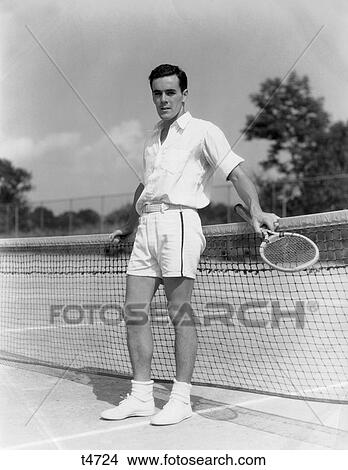 1930S Man In Tennis Whites Standing With Back To Net Holding Racket With Both Hands Resting On The Net Court View Large Photo Image Picture - 1930S Man In Tennis Whites Standing With Back To Net Holding Racket With Both Hands Resting On The Net Court. Fotosearch
