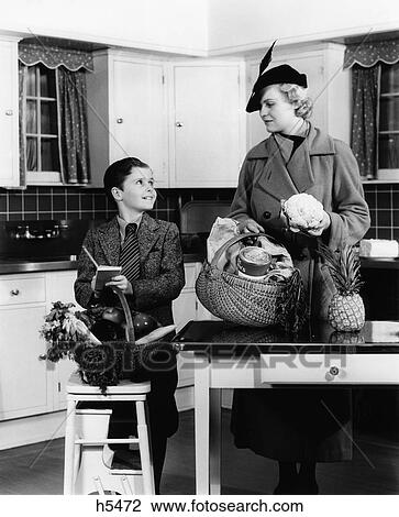 1930S Mother & Son In Kitchen With Baskets Of Groceries Checking Off List View Large Photo Image Stock Image - 1930S Mother & Son In Kitchen With Baskets Of Groceries Checking Off List . Fotosearch