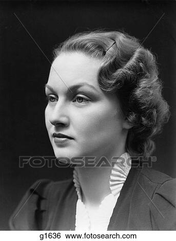 Stock Photograph - 1930S Portrait Of Brunette Woman Looking Off To The Side With A Blank Expression Wearing A White Ruffled Collar . Fotosearch