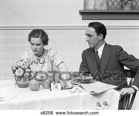 1930S Quarreling Couple At A Table Set For Breakfast The Woman Is Wearing Print Dress Bow View Large Photo Image Stock Photo - 1930S Quarreling Couple At A Table Set For Breakfast The Woman Is Wearing Print Dress Bow . Fotosearch