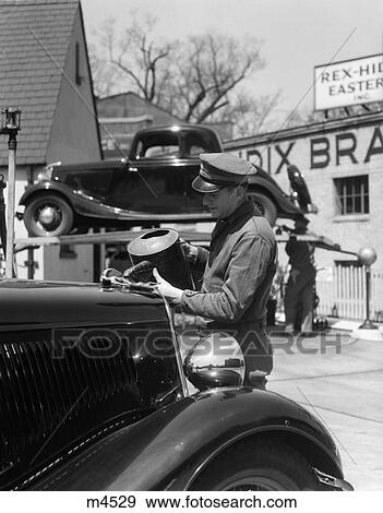 1930S Service Station Attendant In Cap & Coveralls Pouring Water From Spouted Can Into Car Radiator View Large Photo Image Stock Photo - 1930S Service Station Attendant In Cap & Coveralls Pouring Water From Spouted Can Into Car Radiator . Fotosearch