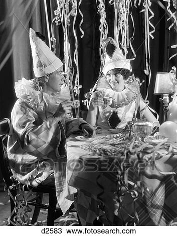 1930S Smiling Couple Drinking Coffee From China Cups Wearing Harlequin Costumes Amid Party Streamers View Large Photo Image Stock Image - 1930S Smiling Couple Drinking Coffee From China Cups Wearing Harlequin Costumes Amid Party Streamers. Fotosearch