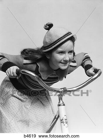 Stock Photo - 1930S Smiling Eager Little Girl Knit Cap Riding Bike . Fotosearch