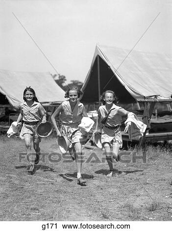 1930S Three Teen Girls Wearing Camp Shorts & Shirts Running From Tents While Holding Towels & Wash Basins View Large Photo Image Stock Image - 1930S Three Teen Girls Wearing Camp Shorts & Shirts Running From Tents While Holding Towels & Wash Basins. Fotosearch