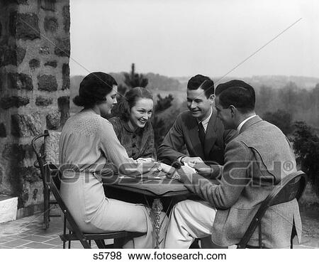 1930S Two Couples Men Women Play Playing Cards At Table On Outdoor Patio Social Card Game Bridge Retro Vintage Lifestyle Upscale View Large Photo Image Stock Photo - 1930S Two Couples Men Women Play Playing Cards At Table On Outdoor Patio Social Card Game Bridge Retro Vintage Lifestyle Upscale. Fotosearch
