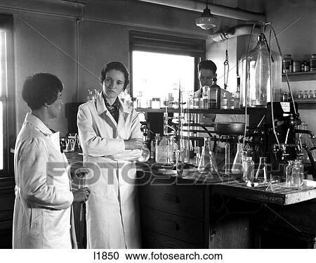 1930S Two Women One Man Wearing Long White Lab Coats Standing Next To Lab Table Chemicals Apparatus Conference Bunsen Burners View Large Photo Image Stock Image - 1930S Two Women One Man Wearing Long White Lab Coats Standing Next To Lab Table Chemicals Apparatus Conference Bunsen Burners. Fotosearch