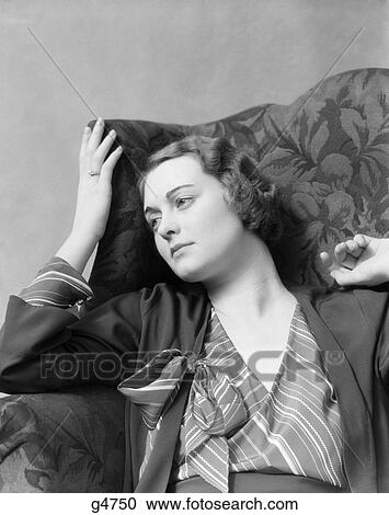 1930s Woman Sitting In High Back Chair With A Thoughtful Or