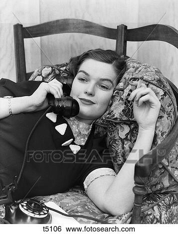 1930S Young Brunette Woman Recline On Pillows Cigarette In Hand Smiling Talk On Telephone Phone View Large Photo Image Stock Photograph - 1930S Young Brunette Woman Recline On Pillows Cigarette In Hand Smiling Talk On Telephone Phone . Fotosearch