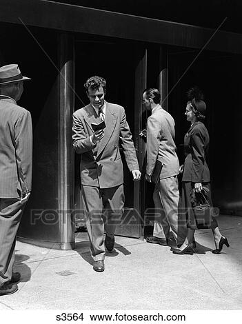 1940 1940S 1950 1950S Business Men And Woman Entering And Leaving Building View Large Photo Image Picture - 1940 1940S 1950 1950S Business Men And Woman Entering And Leaving Building . Fotosearch
